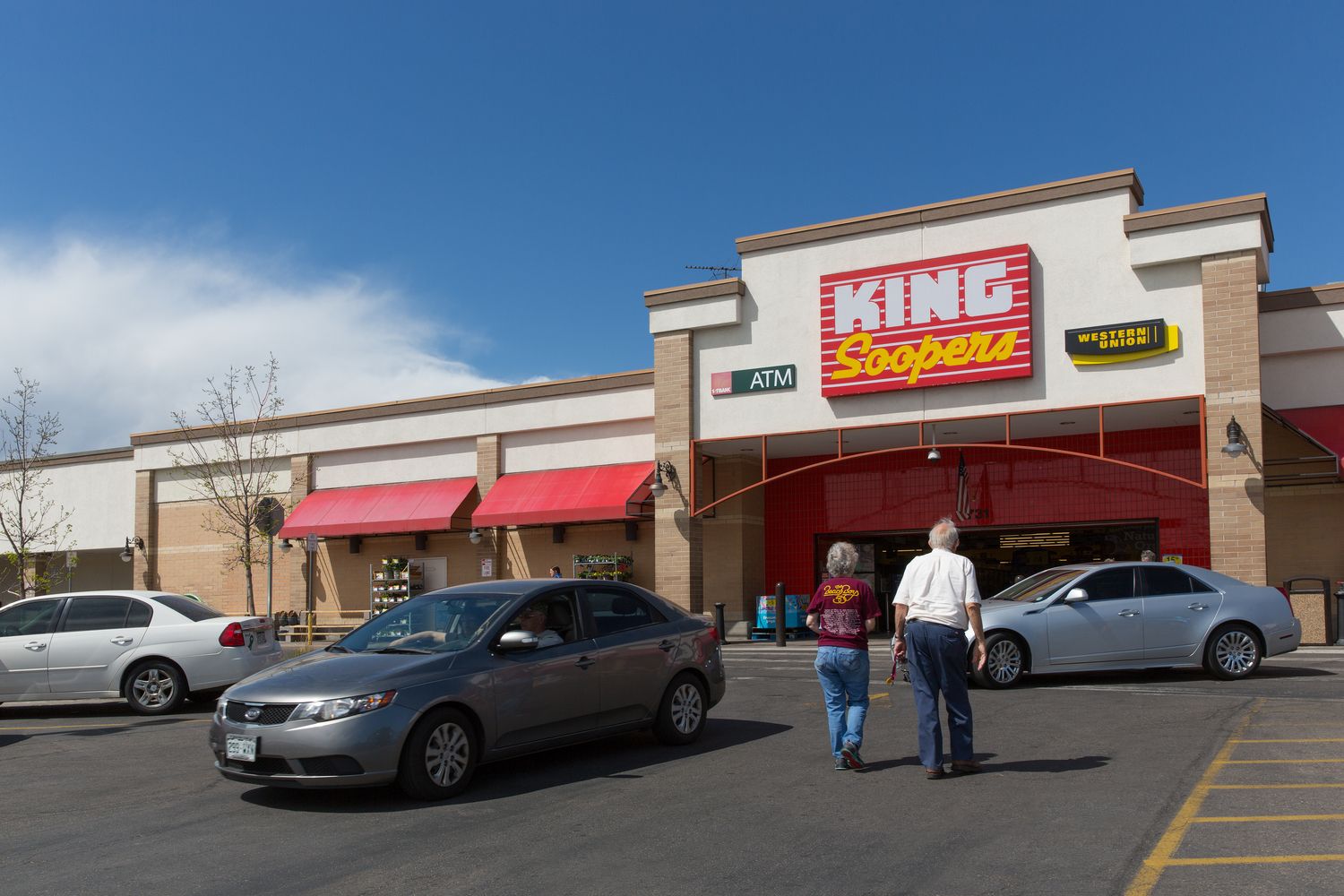 Older couple enter King Soopers through the parking lot of Arvada Plaza