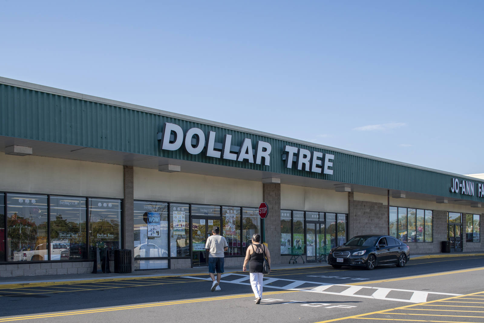 Two customers entering Dollar Tree through crosswalk in Holyoke, MA.