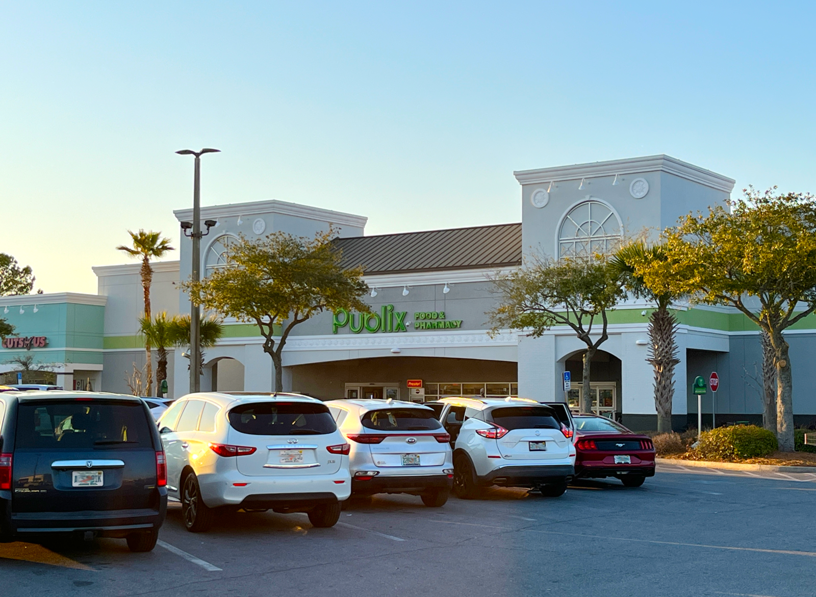Busy parking lot at Publix grocer with trees in front of store.