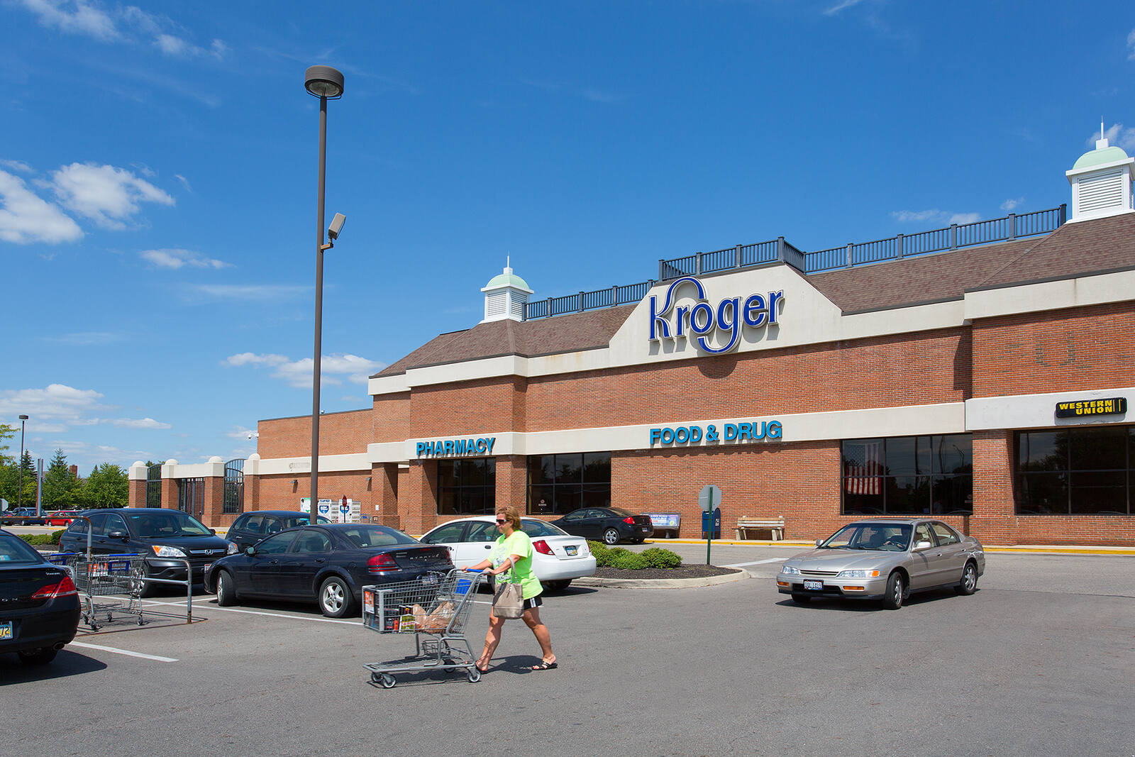 Shopper with car walking through parking lot at Kroger supermarket in Crown Point.