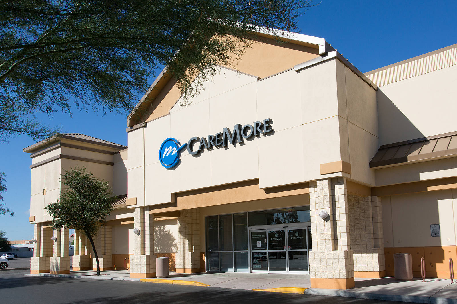 Tree hanging over entrance of CareMore Medical at outdoor shopping center
