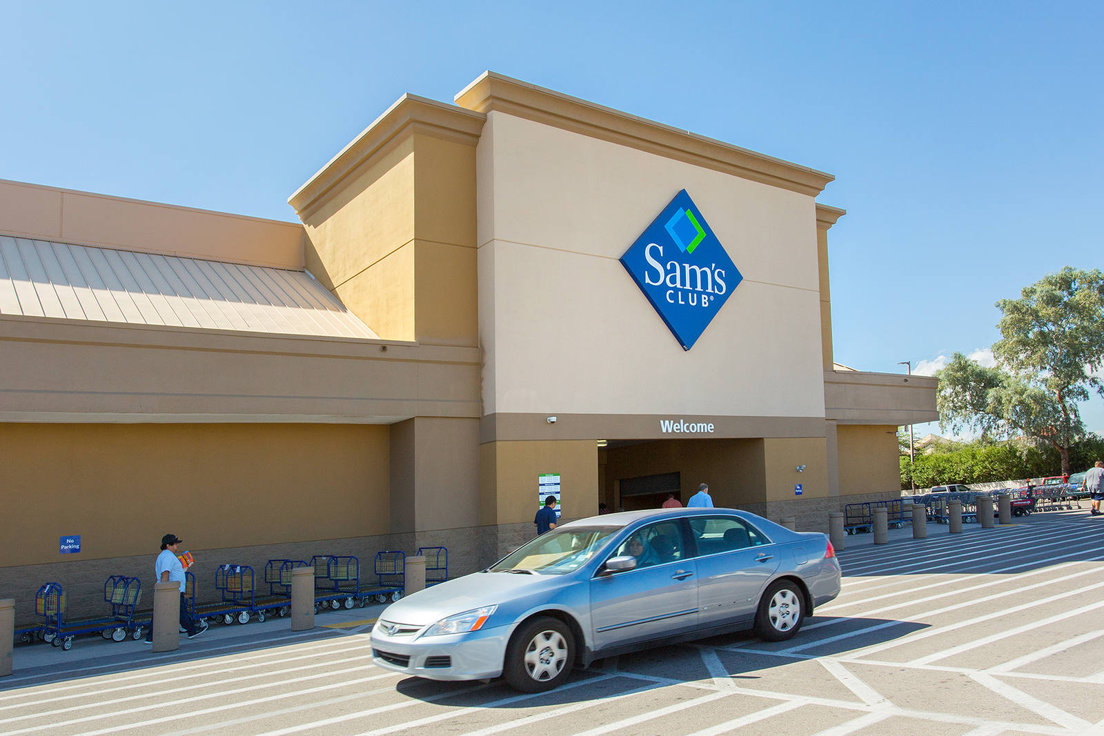 Silver car passing by entrance of Sam's Club