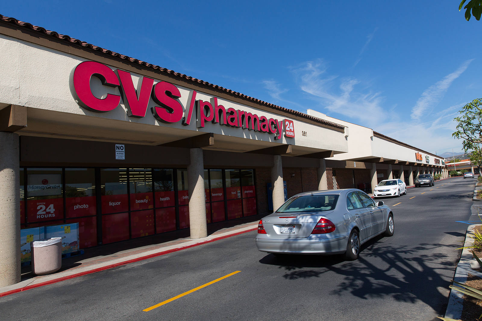 Cars passing CVS Pharmacy at Carmen Plaza.