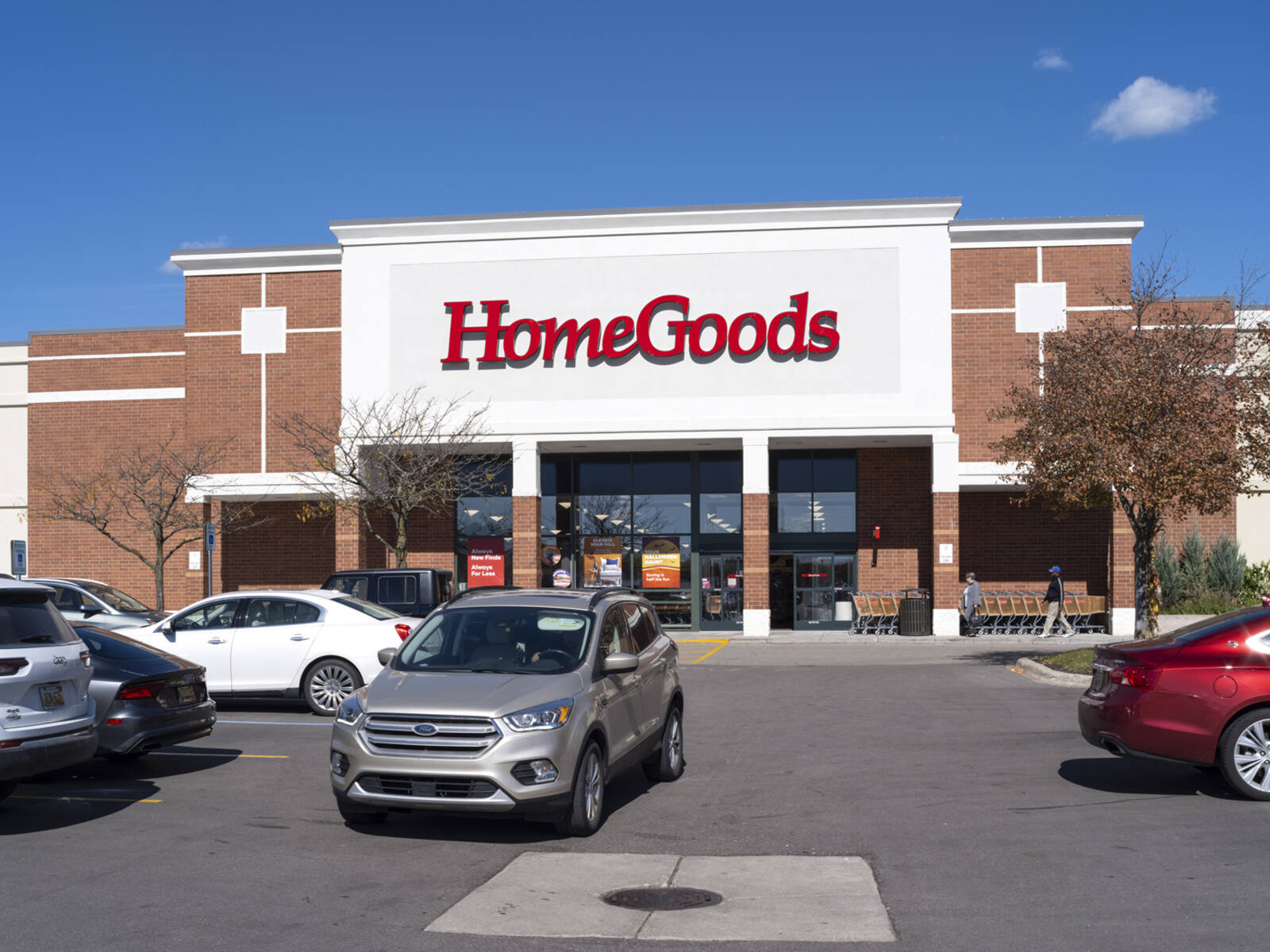 Busy parking lot at HomeGoods with trees in front of store.