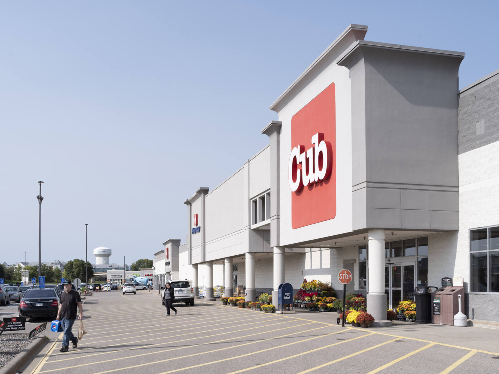 Crosswalk in front of Cub Foods with shoppers carrying bags into the parking lot.
