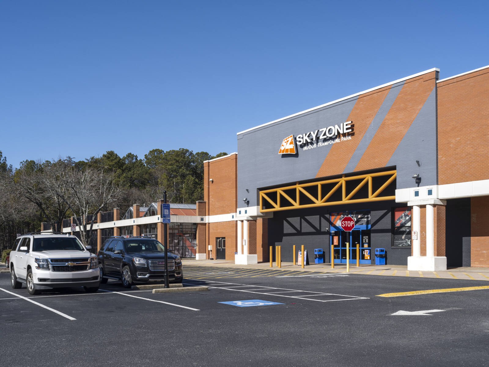 Two cars parked in front of Sky Zone trampoline park.