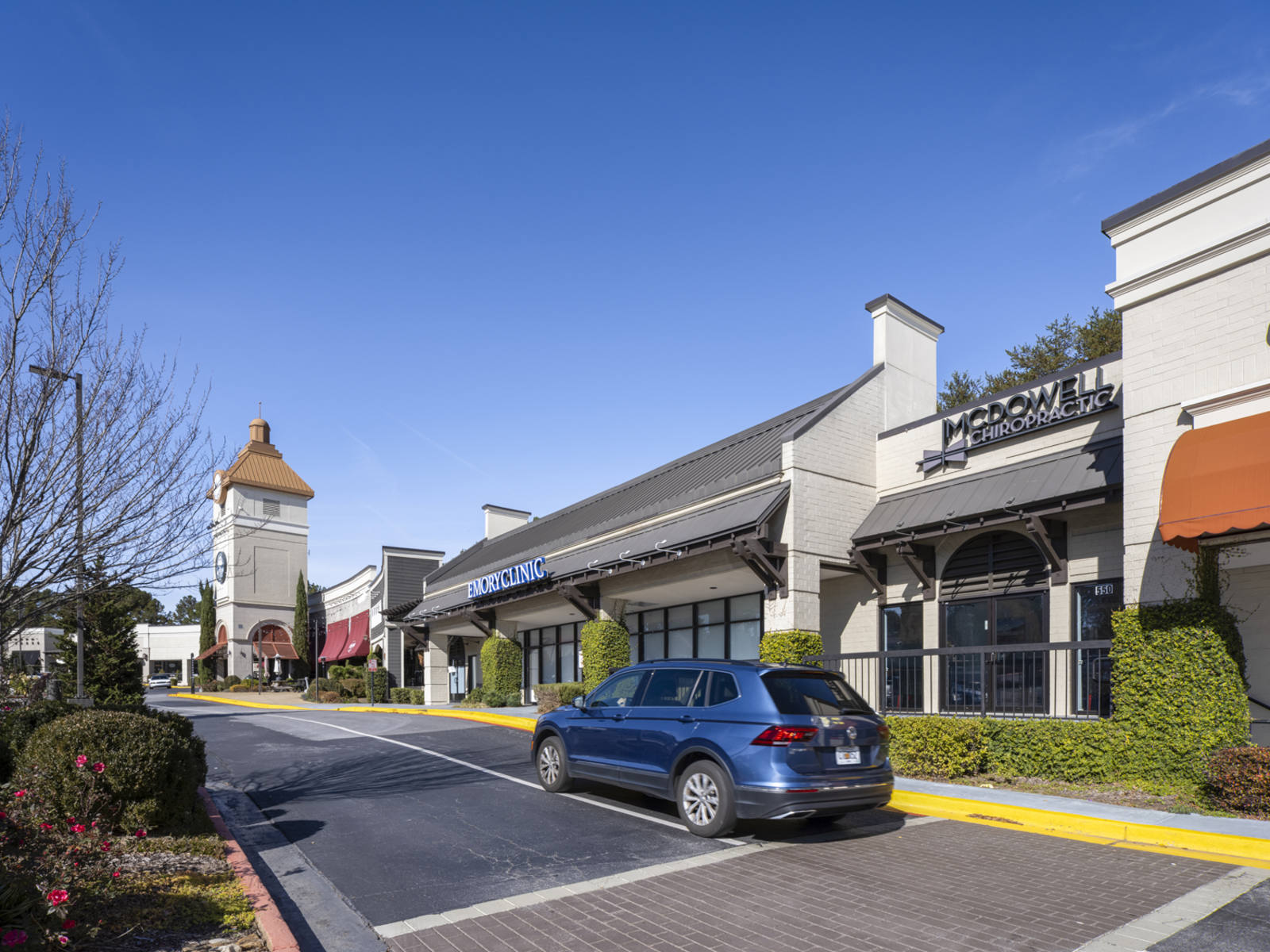 Blue SUV passing shrubs and trees at Connexion.