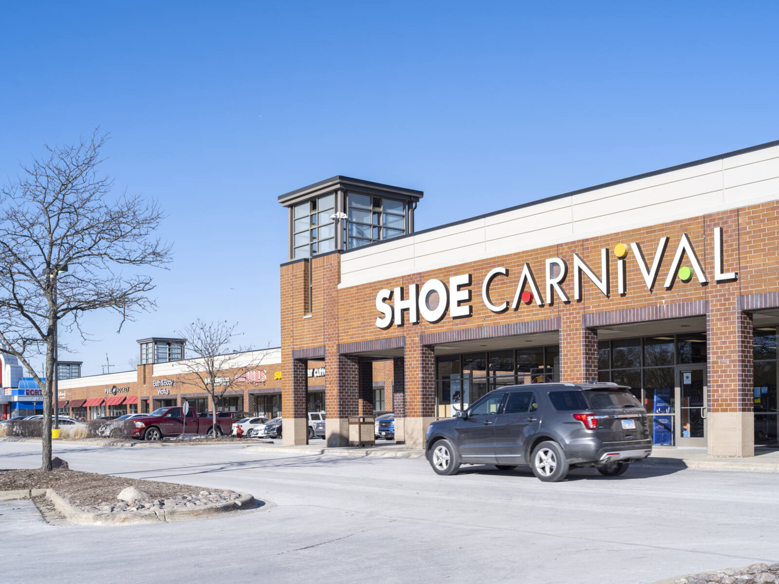 Retail center parking lot and trees at Shoe Carnival.