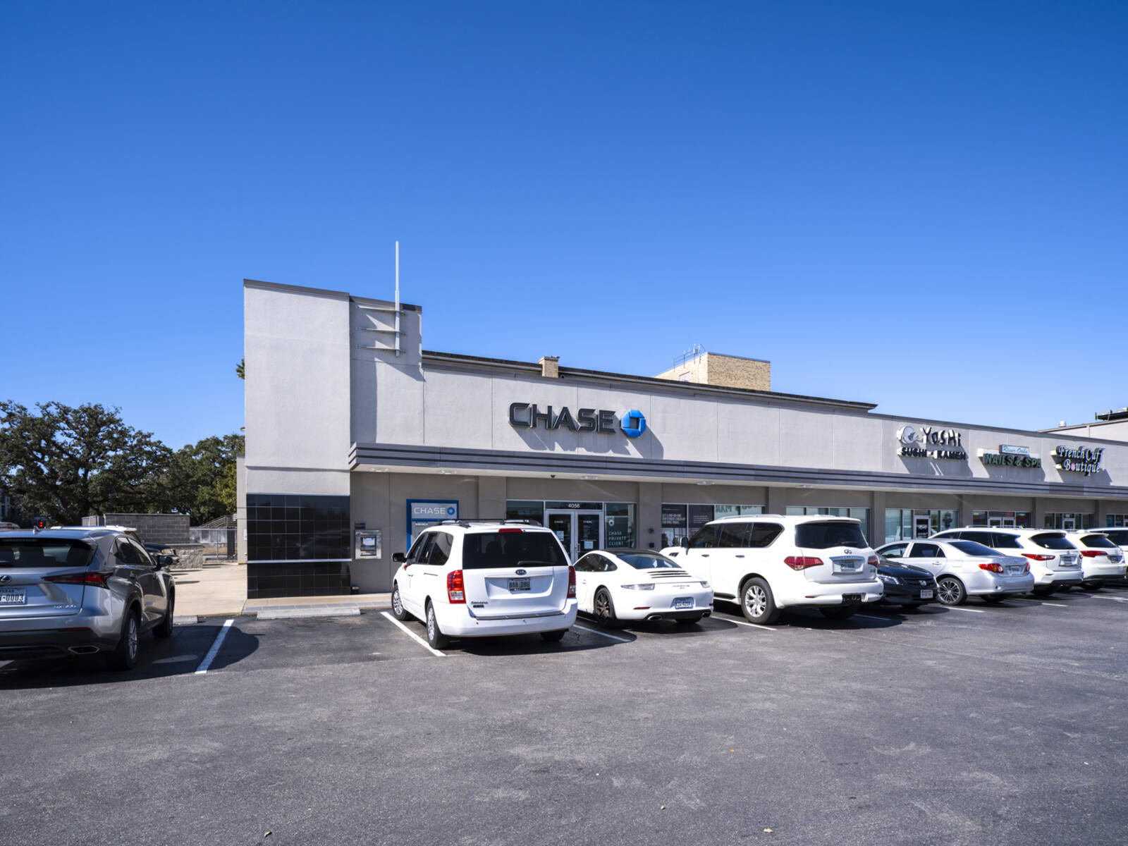 White cars parked in front of Chase Bank and inline shops in Houston, TX.