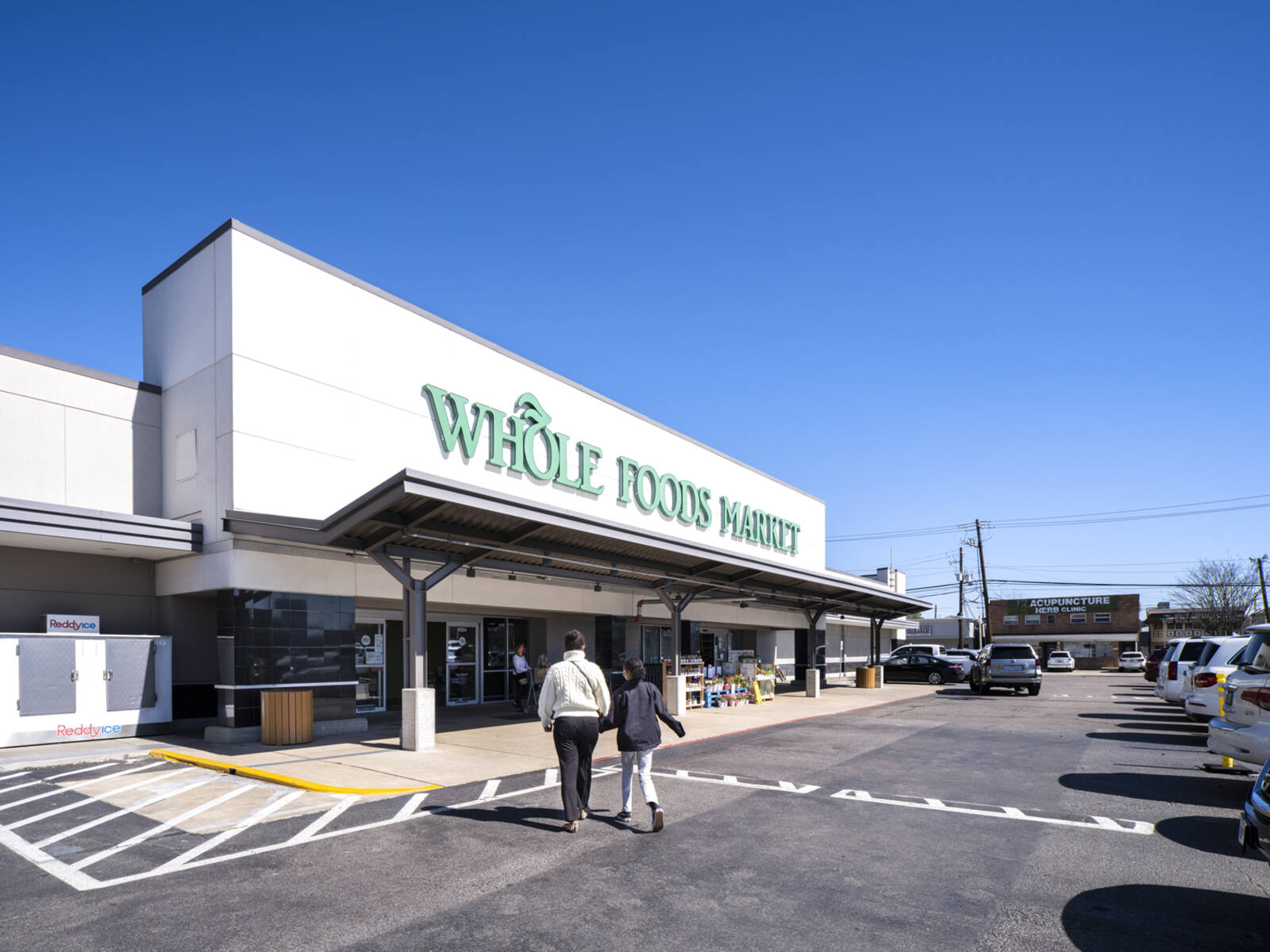 Customers approaching Whole Foods Market grocery store in Houston, TX.