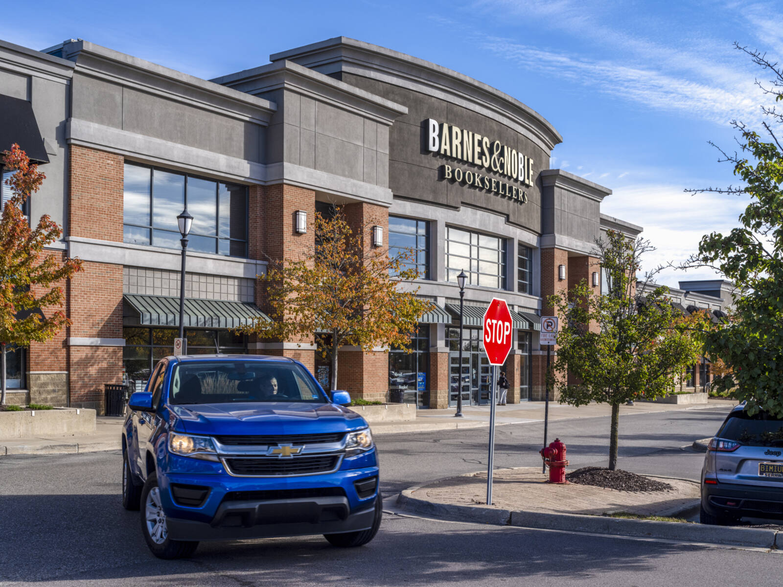Blue SUV passing turn at Barnes & Noble store.