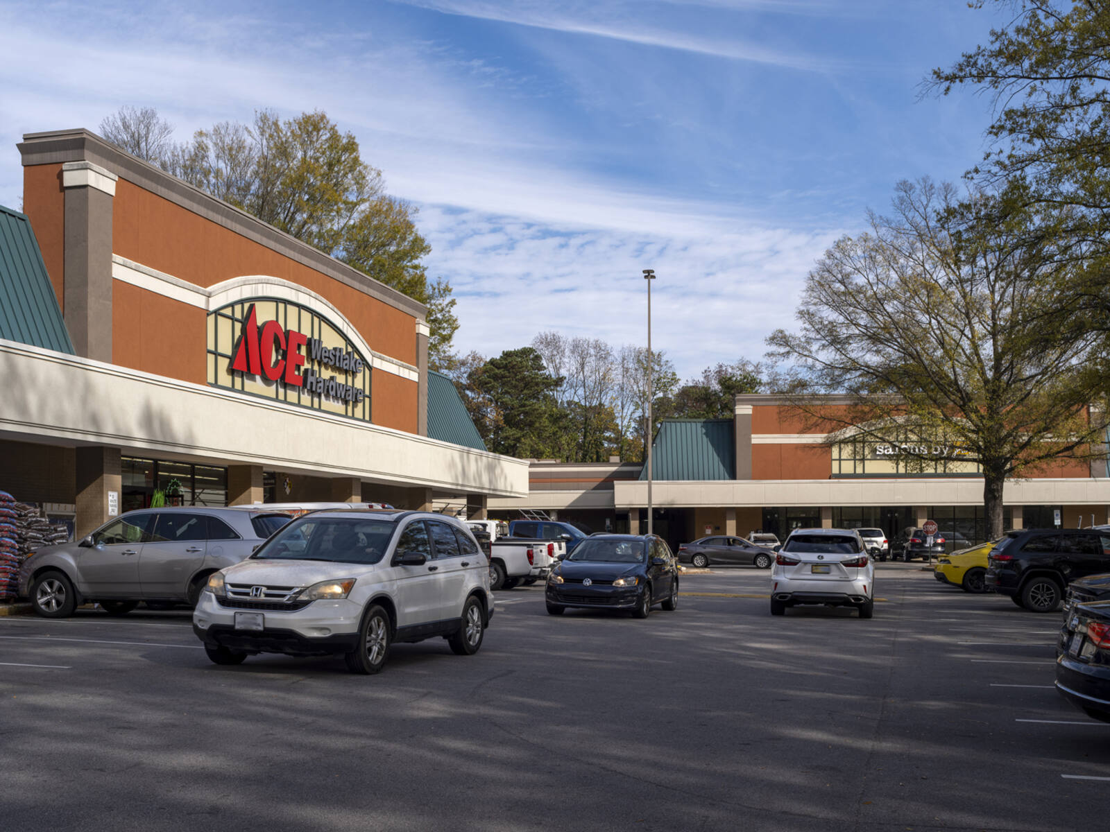 Cars passing in front of ACE Hardware store.