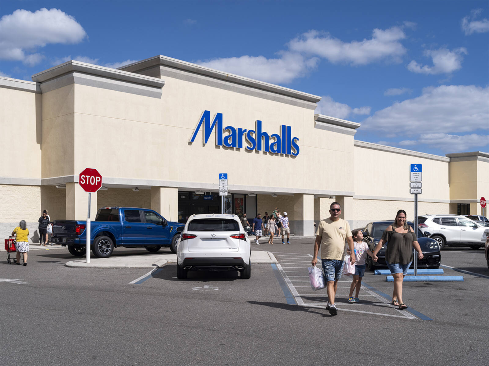 Front of Marshalls with people walking in and out of a busy parking lot.
