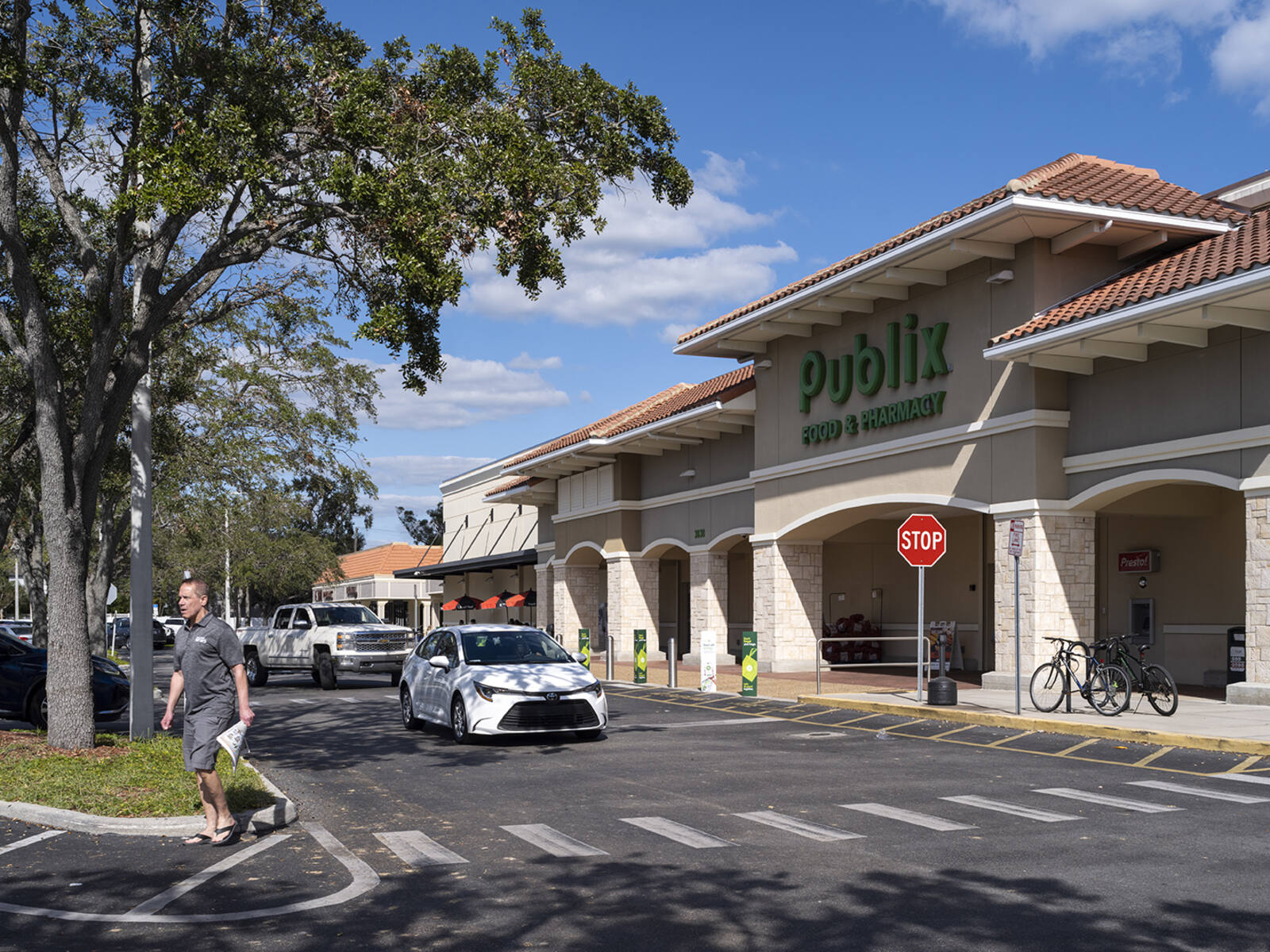 Entrance to Publix with cars and people.
