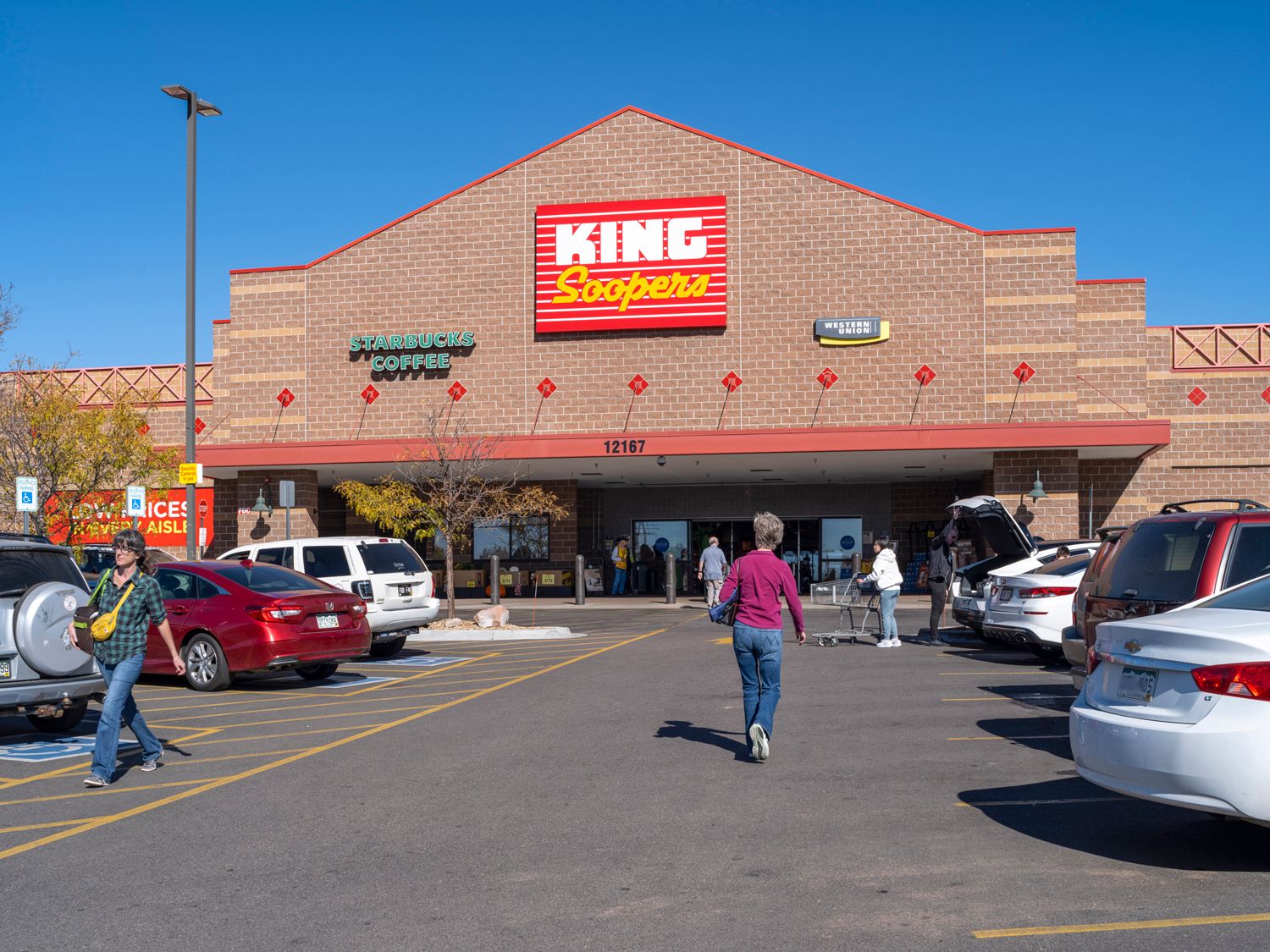 King Soopers grocer with patrons in parking lot.