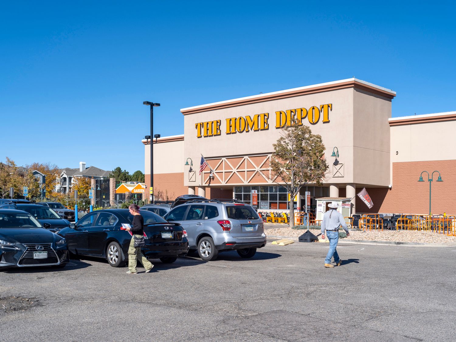 Customers entering cars in Home Depot parking lot.