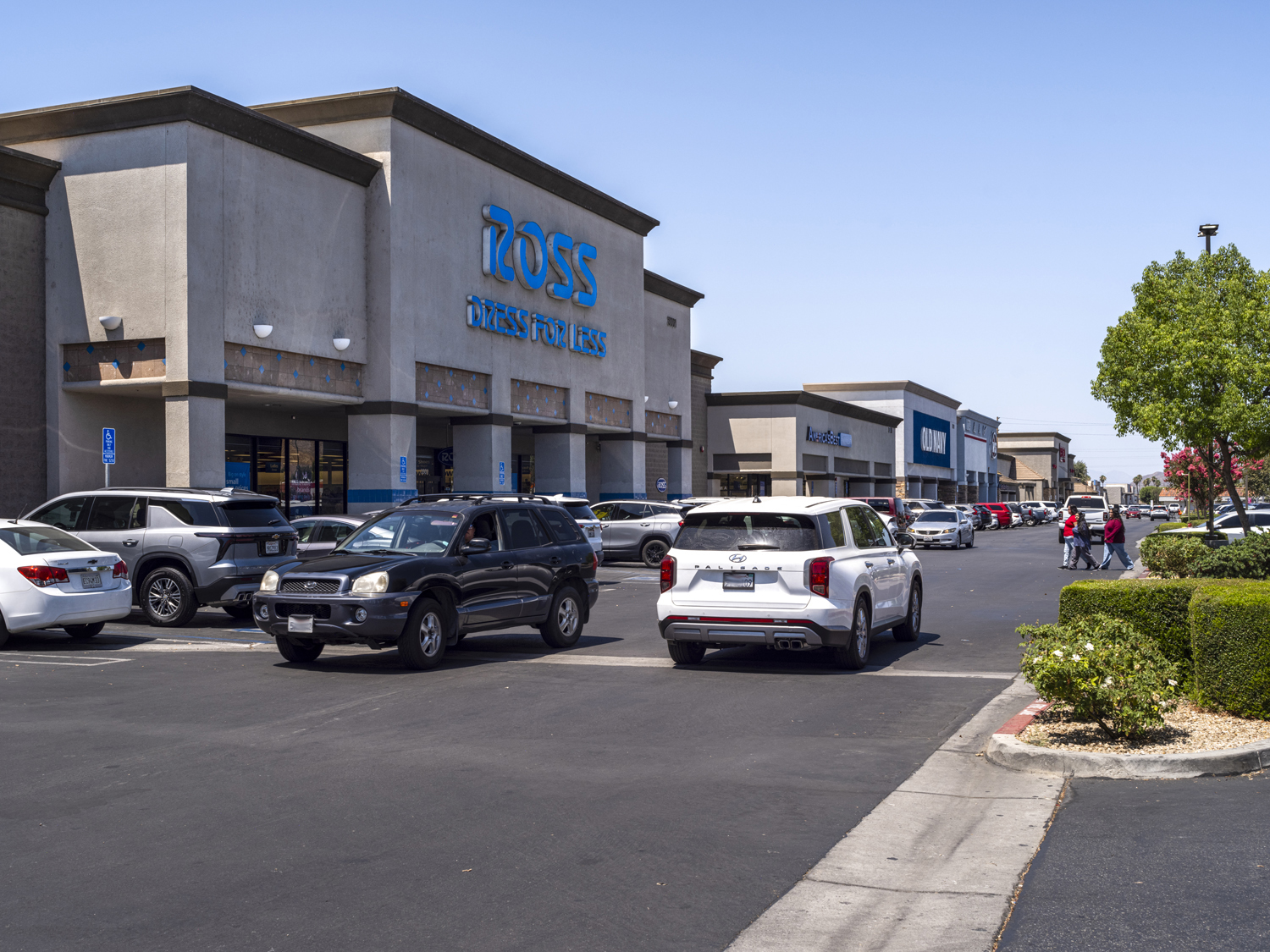 Busy parking lot with shoppers and cars in crosswalk of Ross Dress for Less.