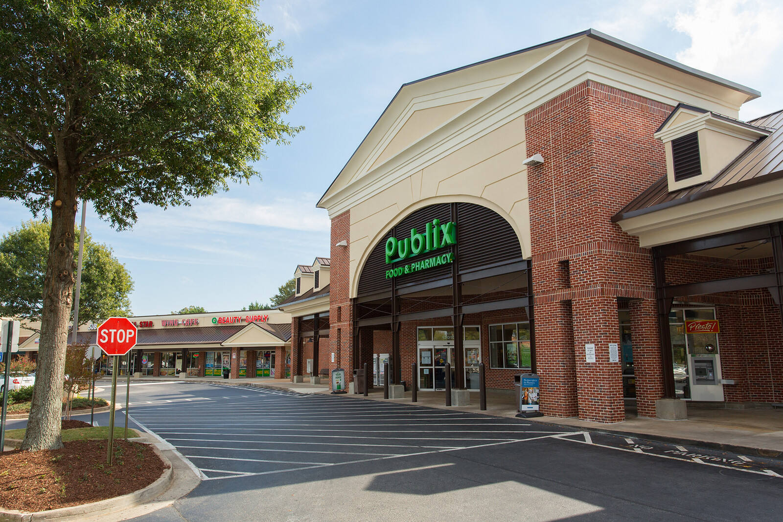 Green tree across from entrance of Publix at Salem Road Station shopping center