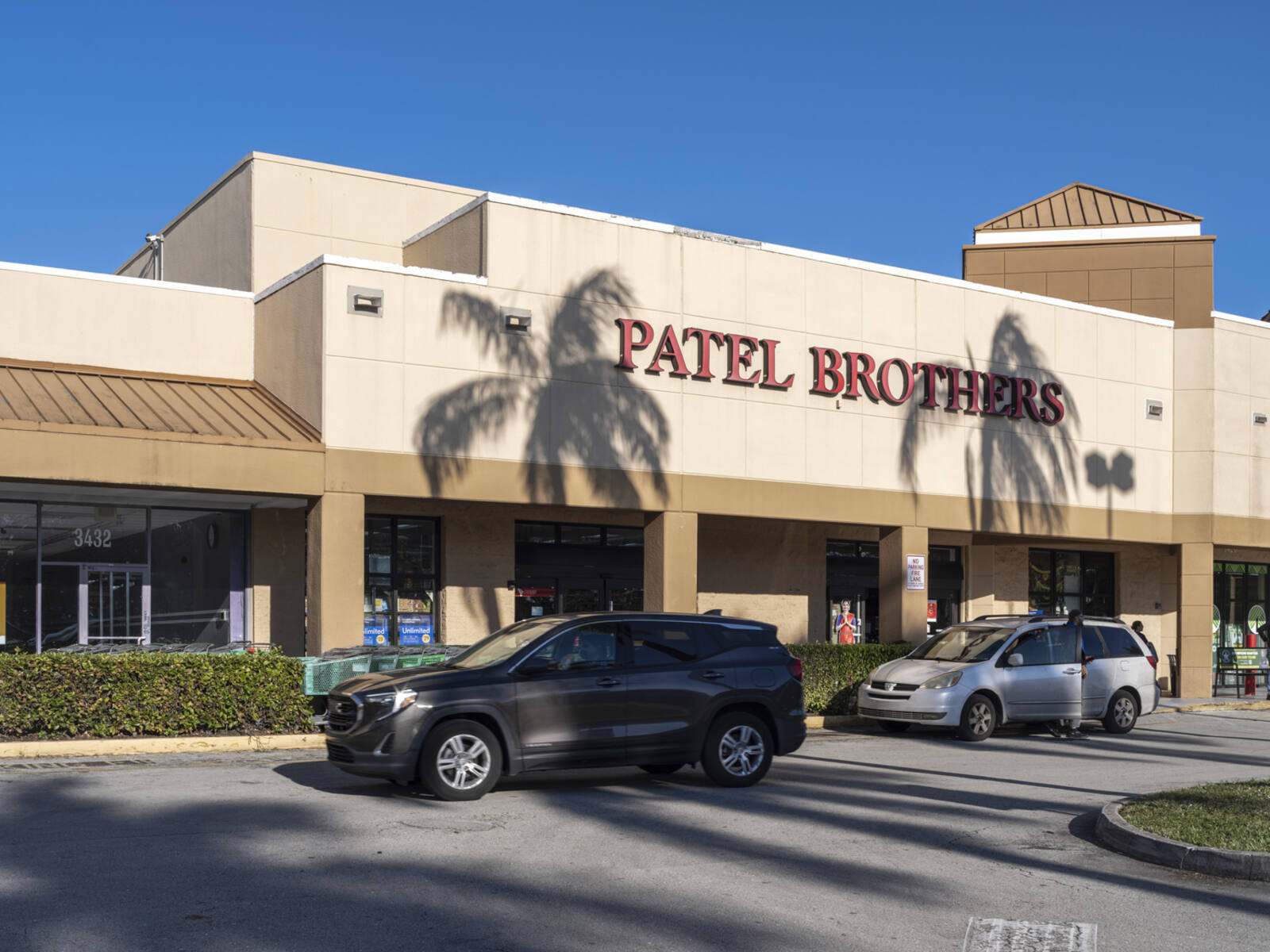 2 SUVs in front of Patel Brothers supermarket.