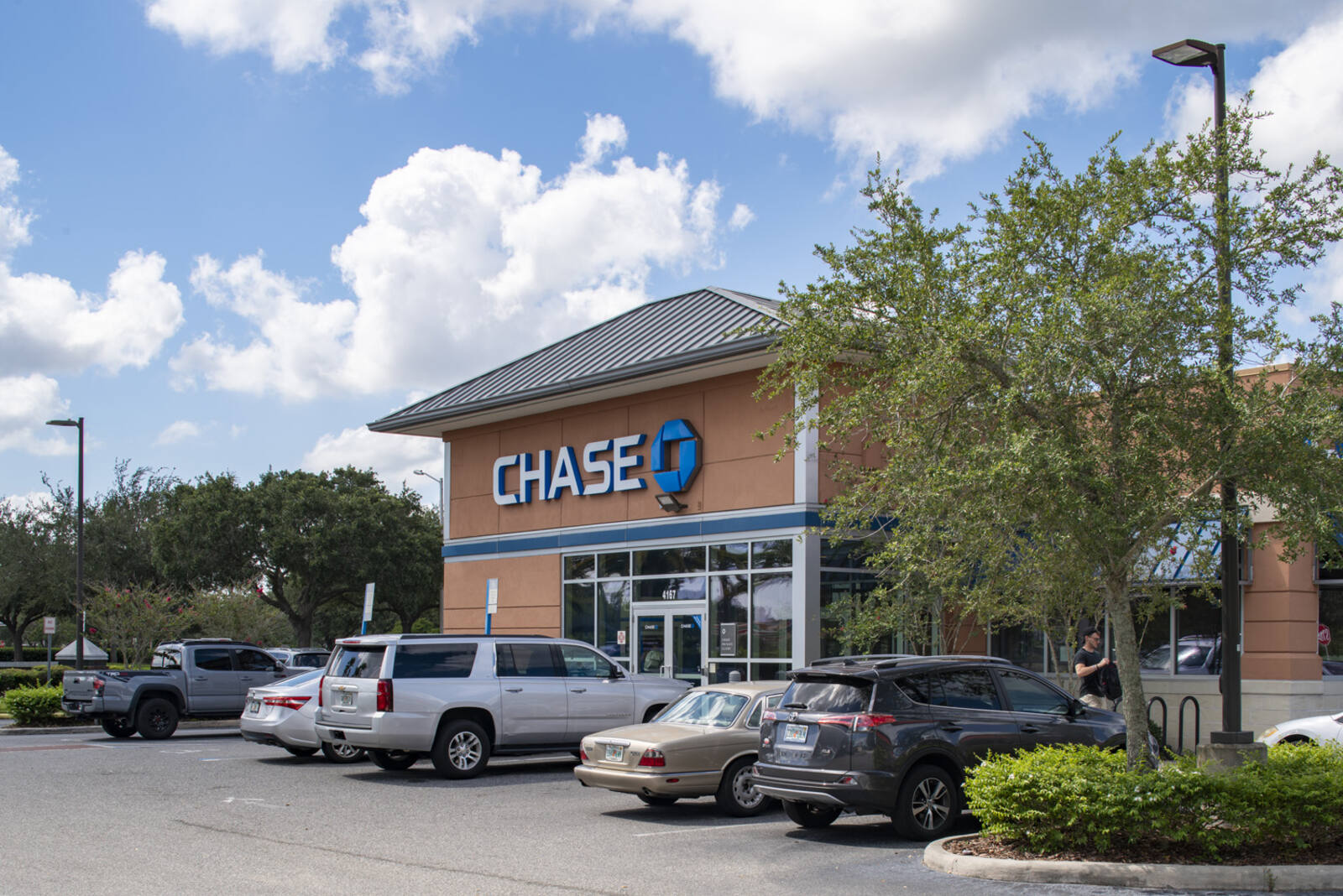 Full parking lot at Chase bank surrounded by trees.