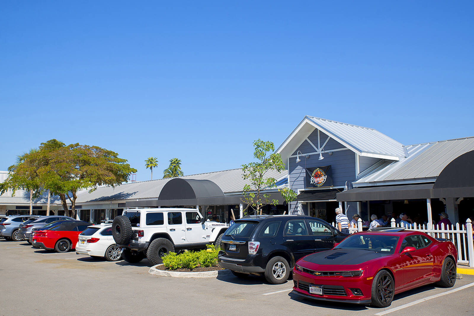 Trees and busy parking lot at Marco Island Brewery at Marco Town Center.