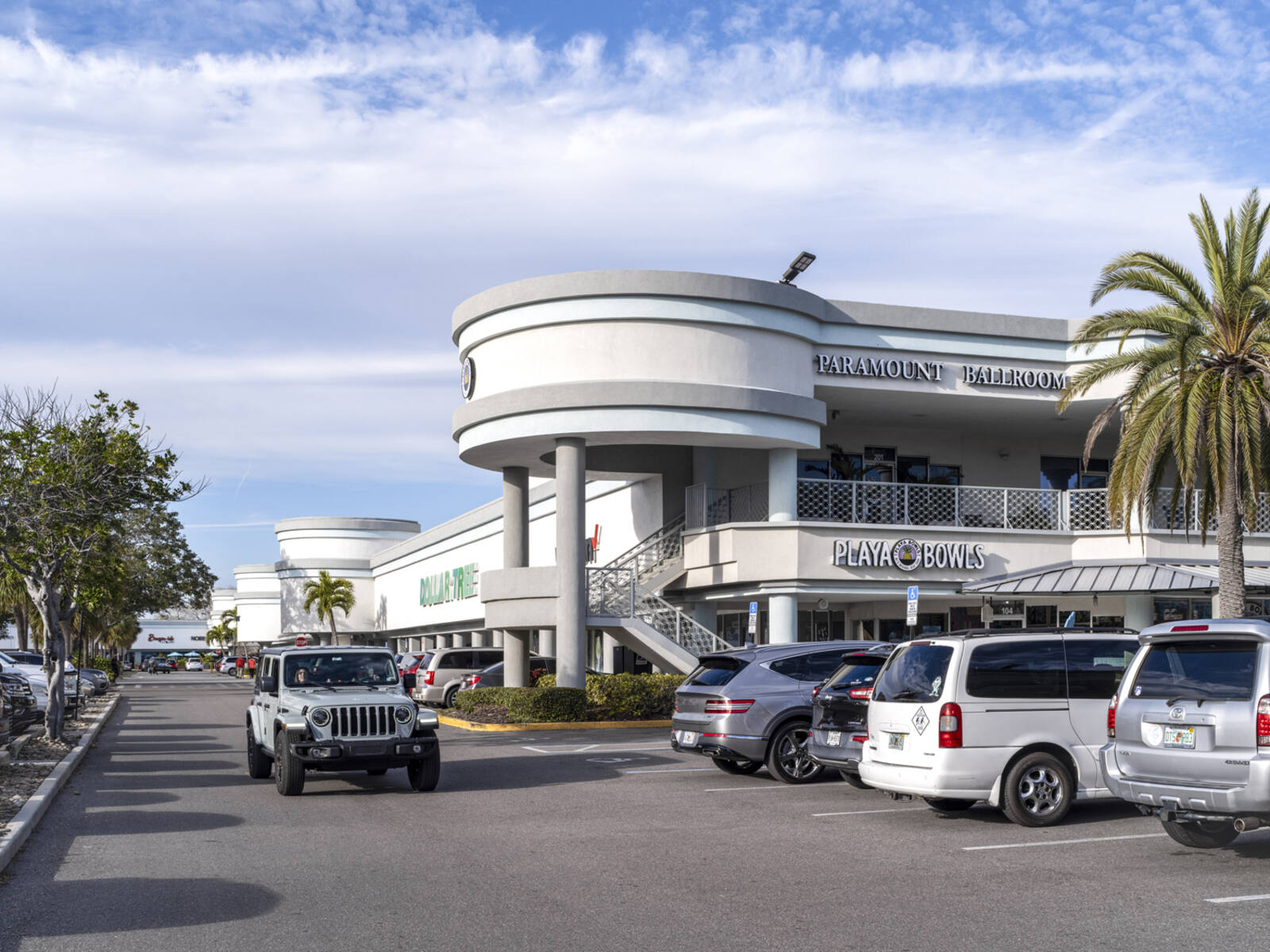 Busy parking lot in front of Playa Bowls and Dollar Tree.