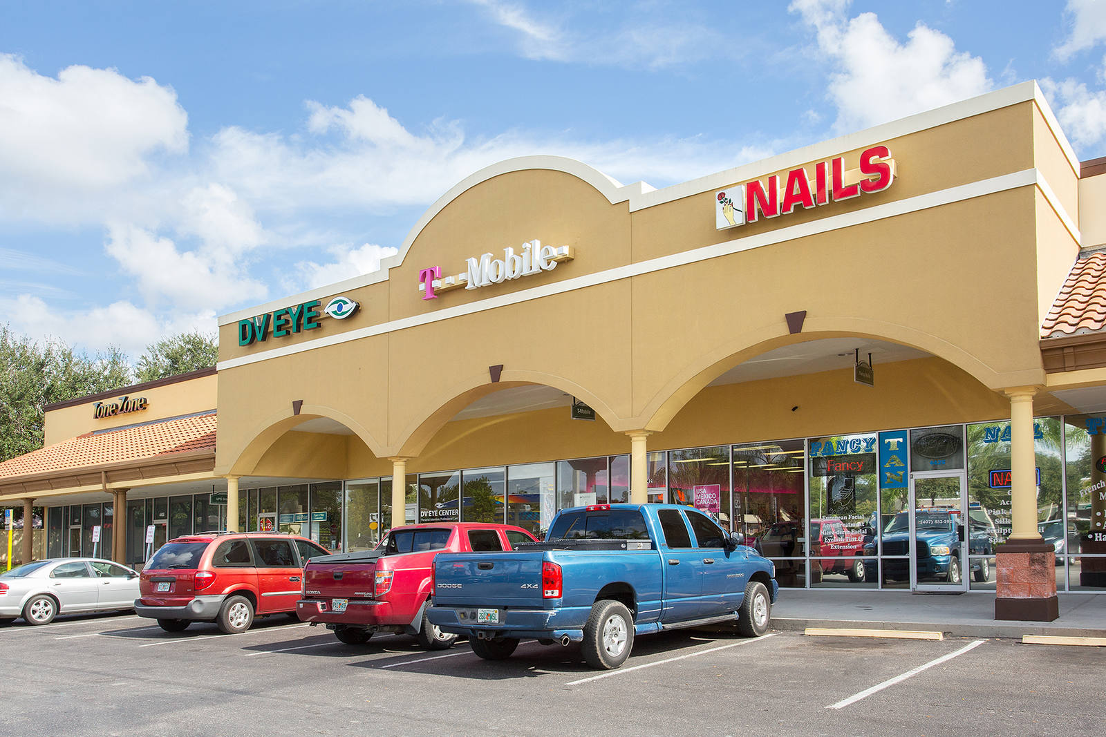 Trucks and cars parked at T-Mobile and inline shops at Conway Crossing.