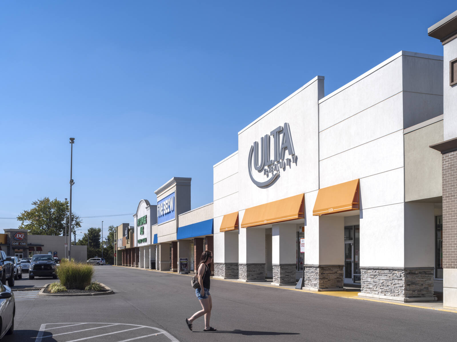 Woman approaches Ulta Beauty with Five Below behind it.