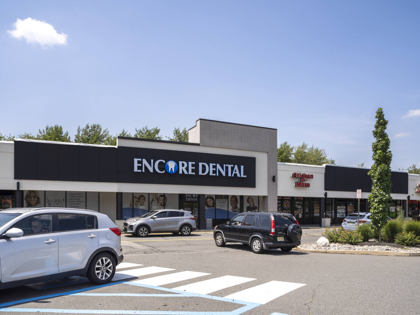 Car turning onto road in front of Encore Dental in parking lot.