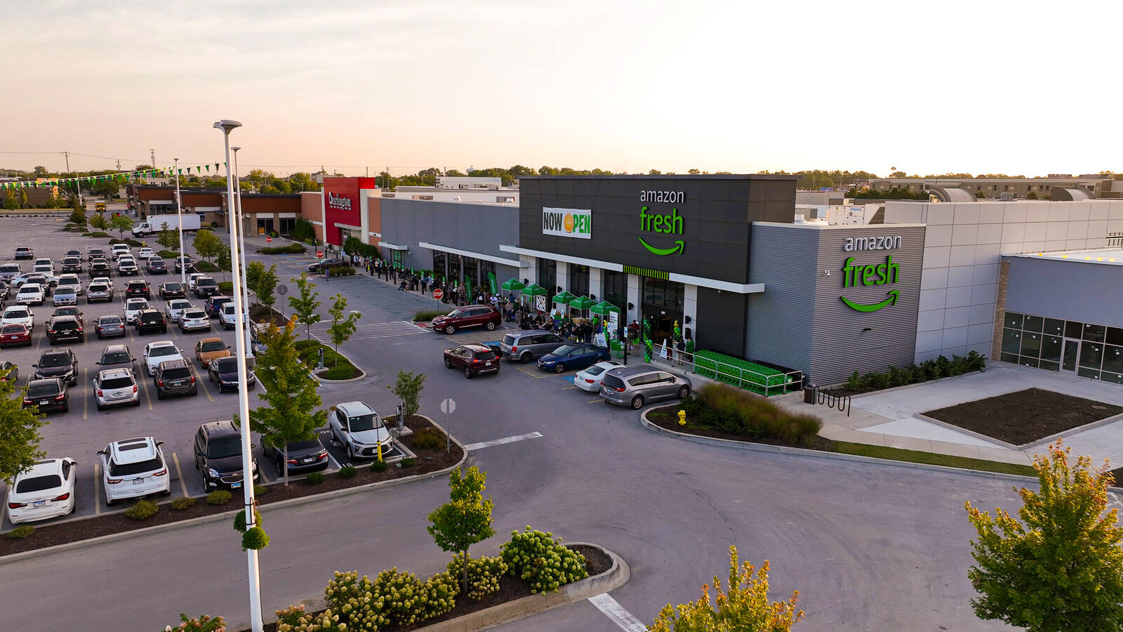 Busy parking lot and customer line in front of Amazon Fresh for opening.