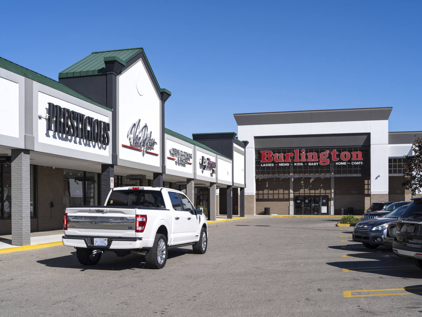 White truck approaches Burlington via parking lot road.