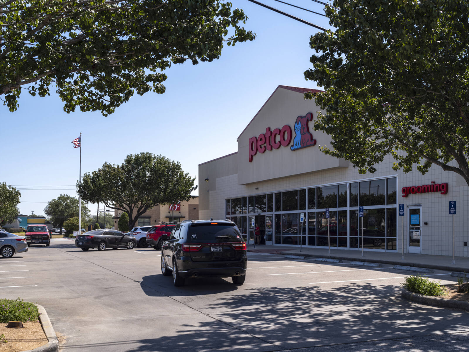 Black SUV driving towards Petco parking lot.