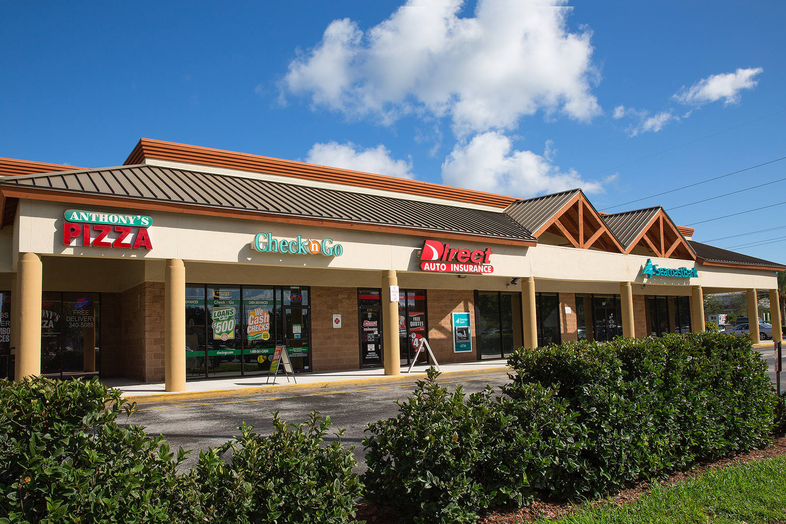 Green hedges line small shops at Shoppes of Victoria Square
