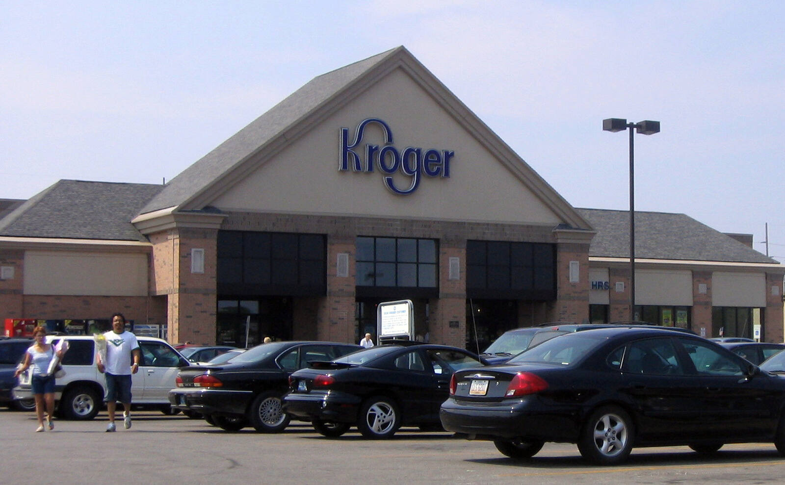 Kroger supermarket with customers and cars in lot at Miracle Mile Shopping Plaza.