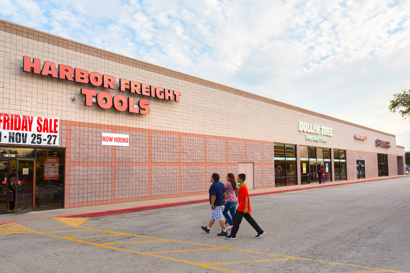 Three people walking towards entrance of Harbor Freight Tools at Parmer Crossing shopping center