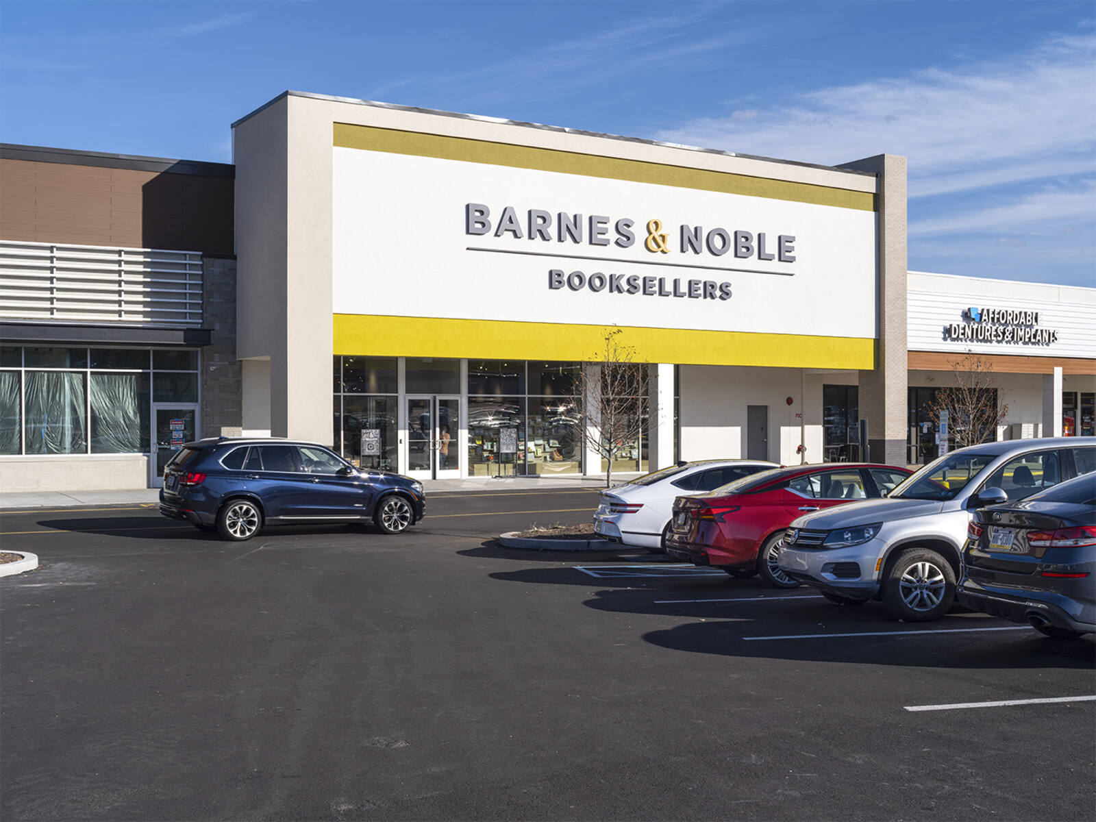 Barnes & Noble façade with parked vehicles. 