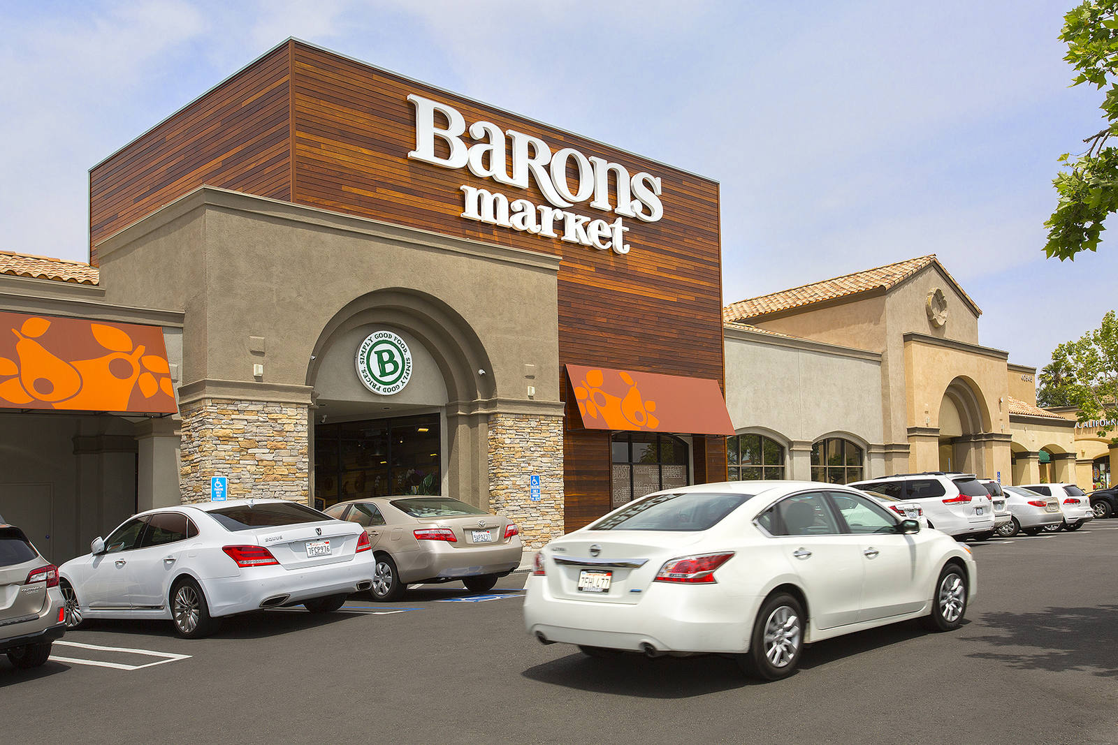 White car passing the parking lot at Barons Market in Murrieta, CA.