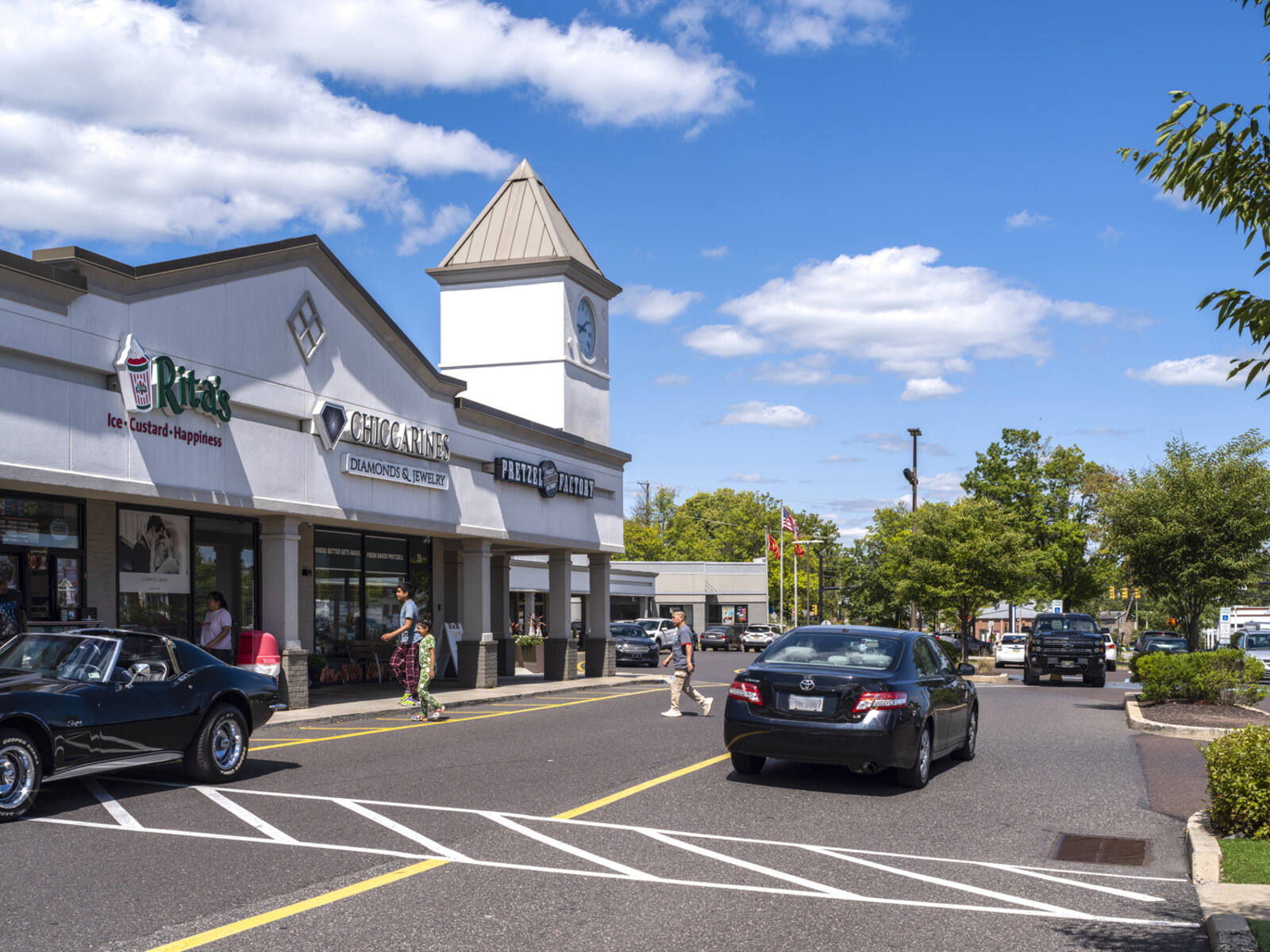 Busy intersection on access road in front Pretzel Factory and Rita's in a shopping center.