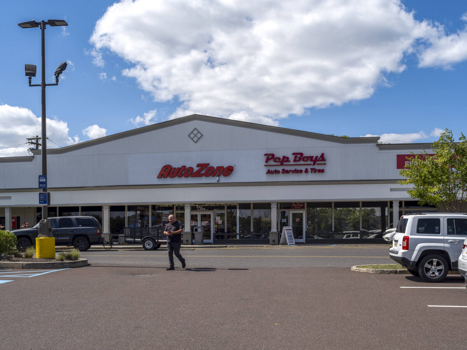 Man in parking lot in front of AutoZone and Pep Boys.