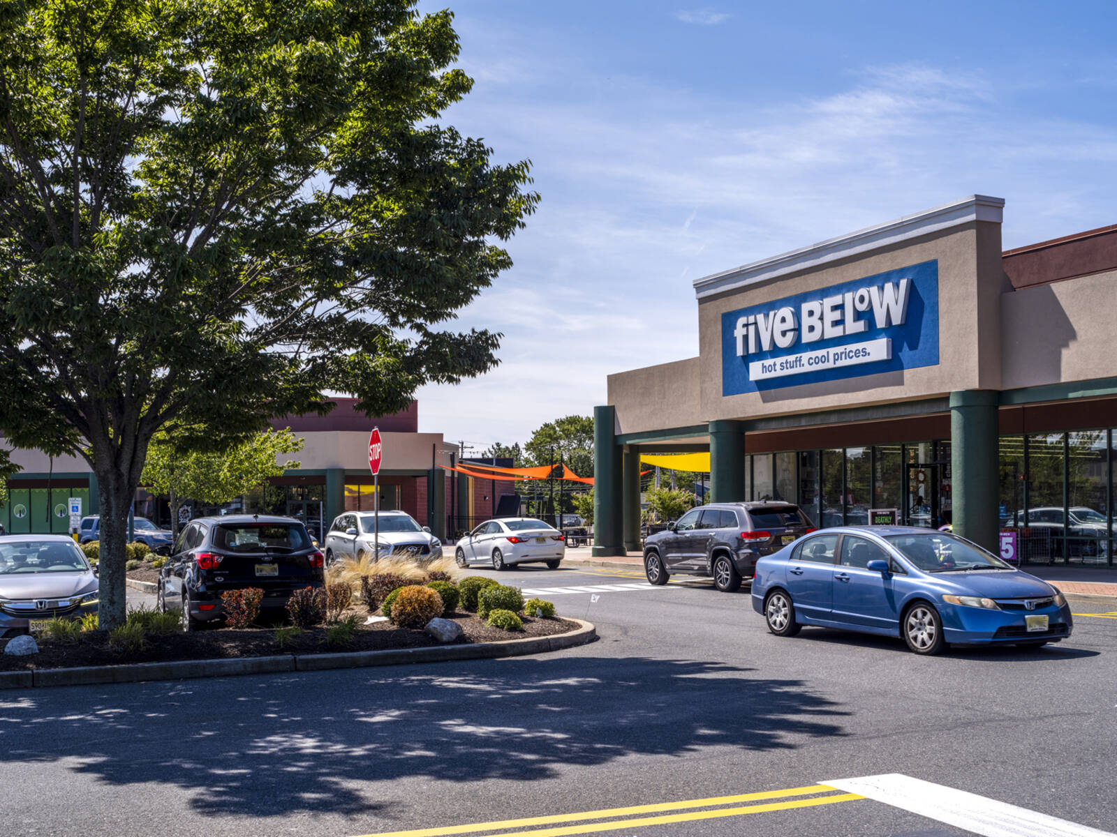 Five Below store with trees and parking lot at entrance.