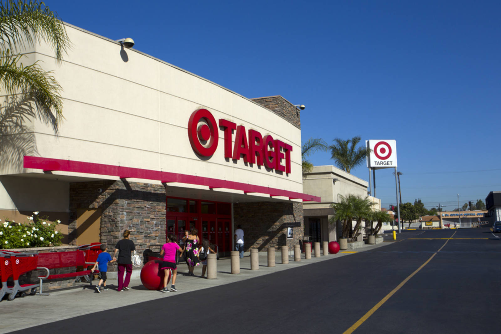 People walking towards entrance of Target at an outdoor shopping center on a clear day