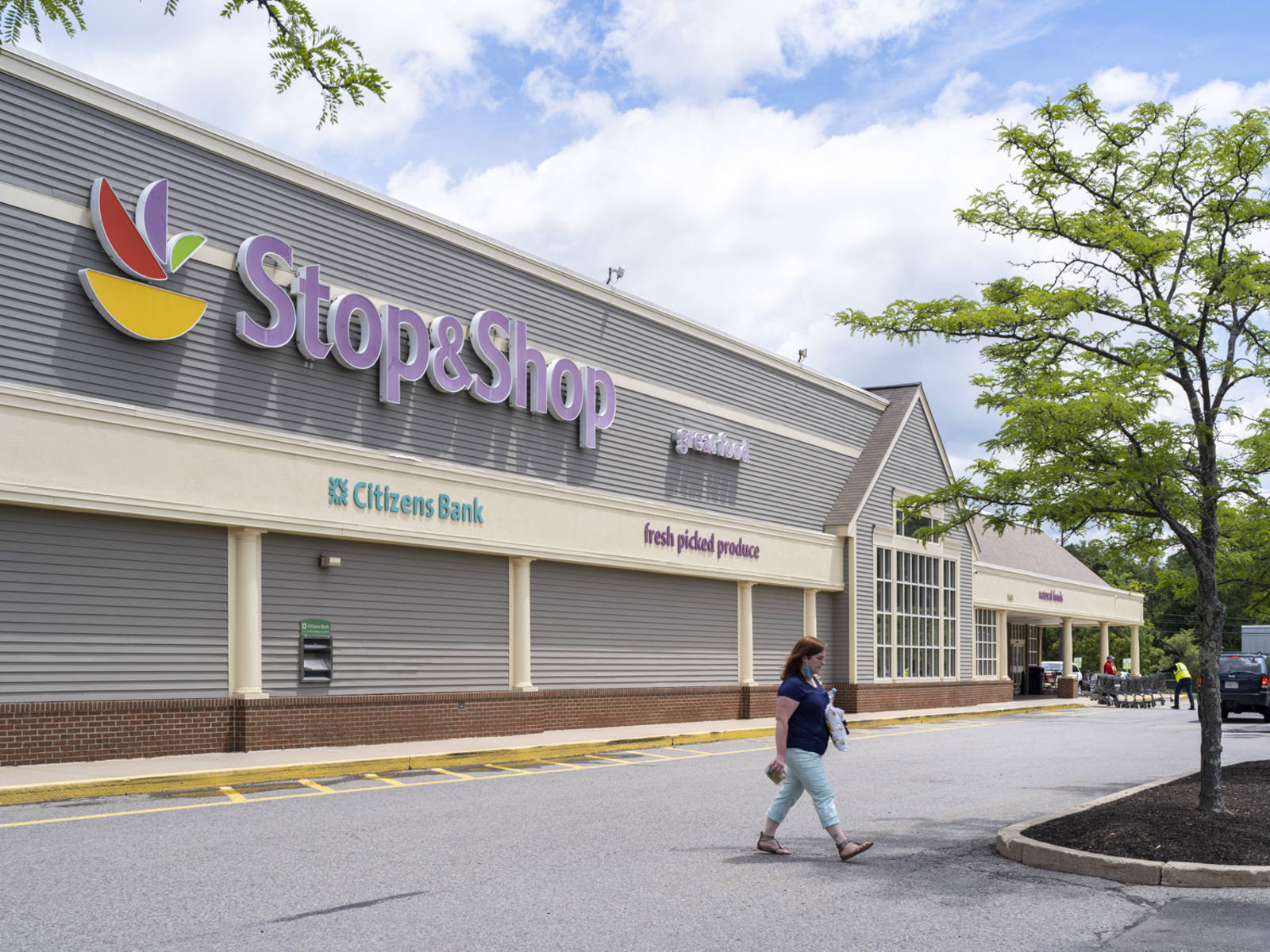Person with blue top walking across parking lot of Stop & Shop