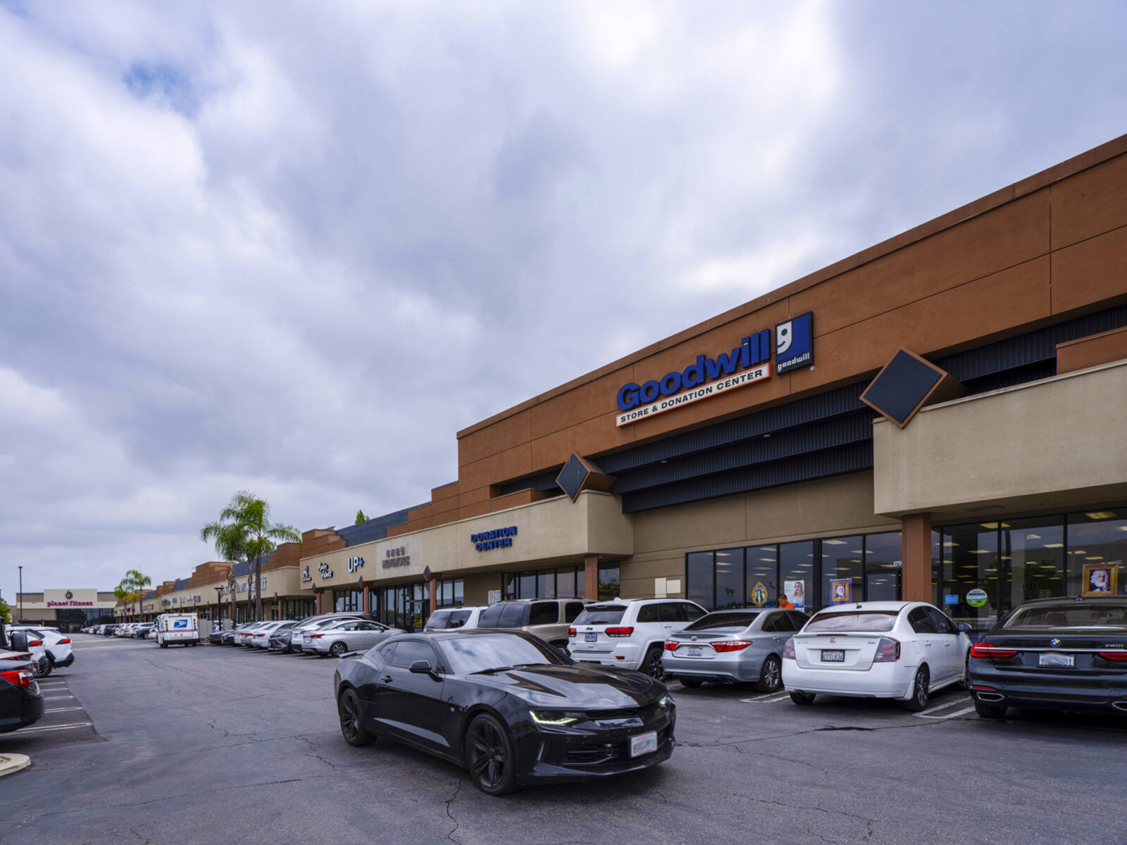 Sports car passes other parked cars at Goodwill store at Puente Hills Town Center.