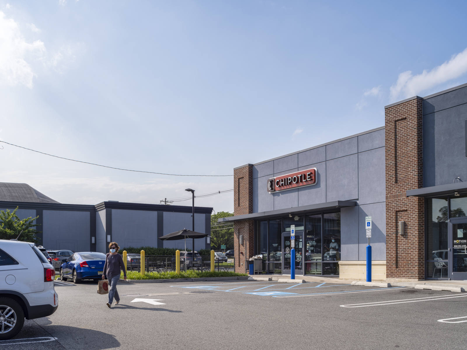 People walking through parking lot of Chipotle