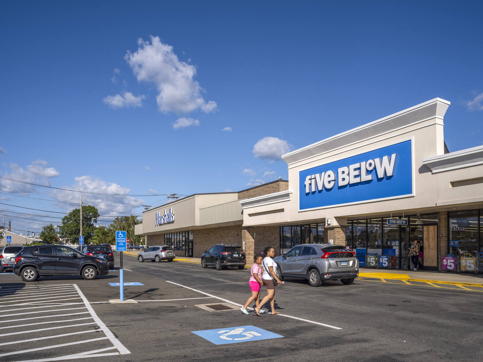 2 people approach Five Below via the parking lot.