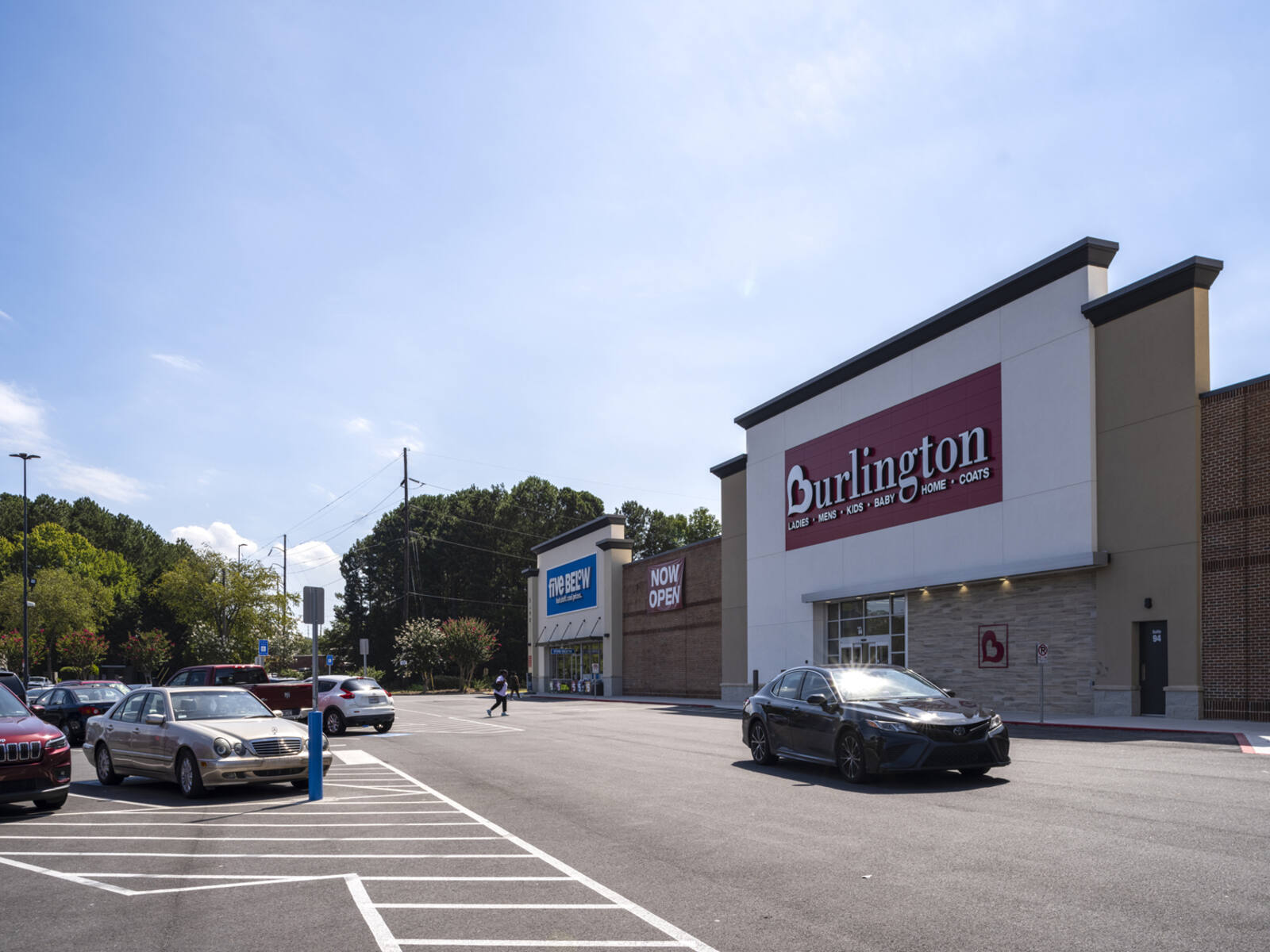 Car passing Burlington store in front of parking lot.