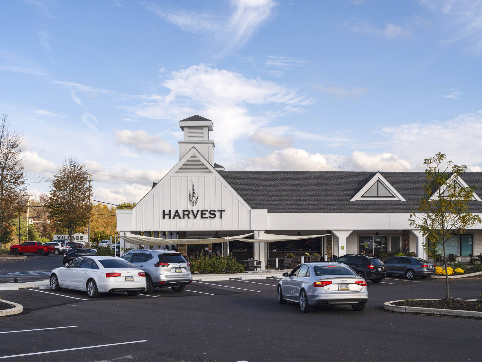 Cars parked outside of Harvest during the fall at Village at Newtown shopping center