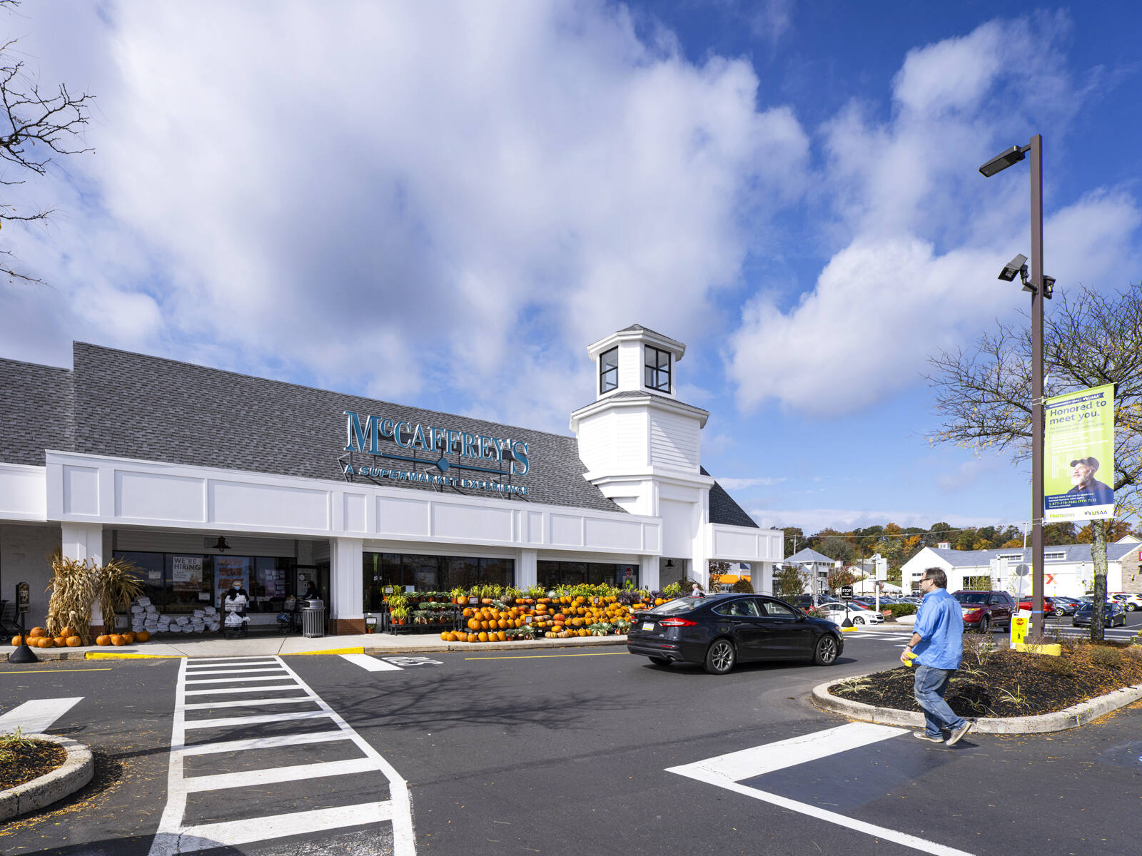 Pumpkin's lining entrance of McCaffrey's as person wearing blue walks through parking lot