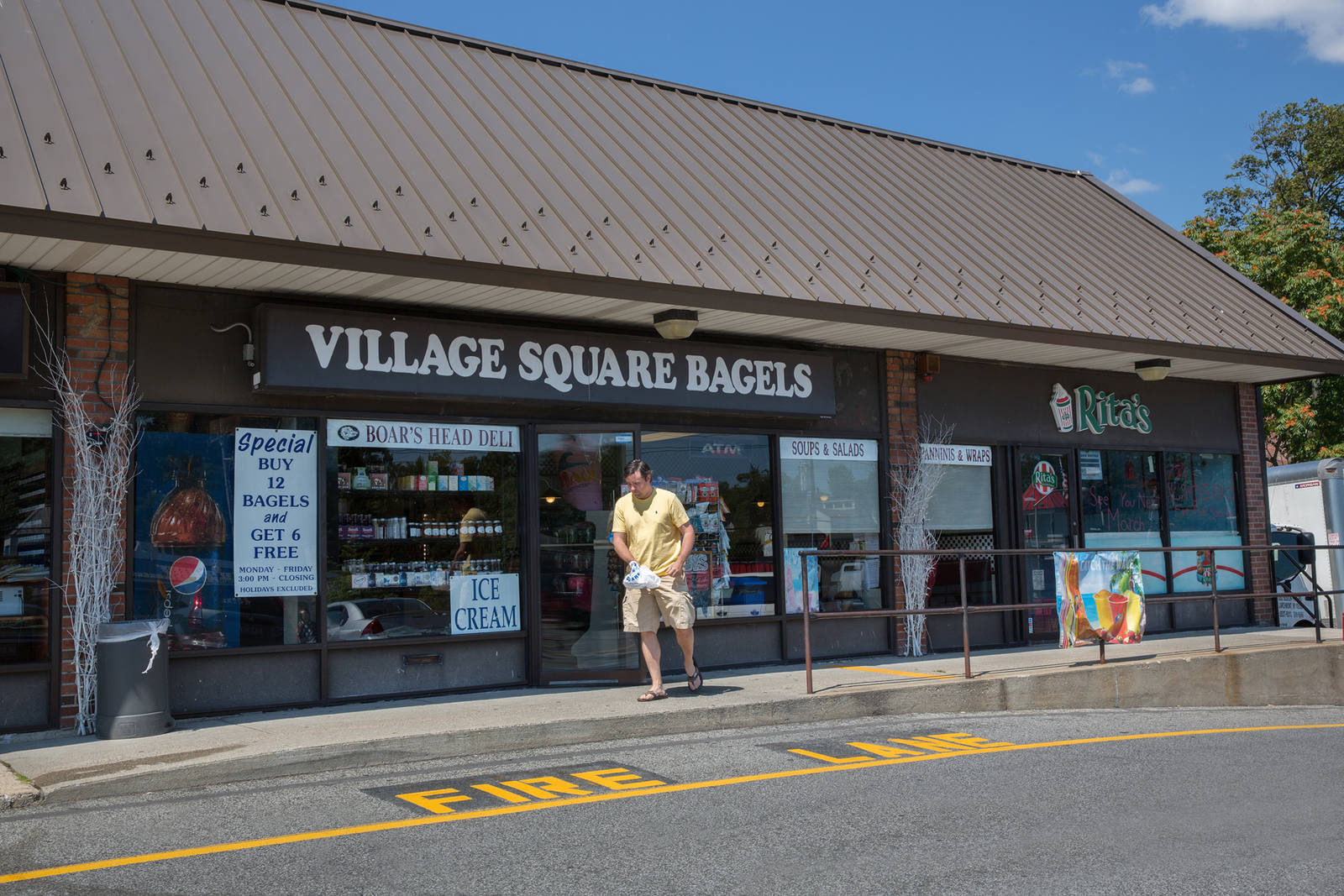 Man walking out of Village Square Bagels