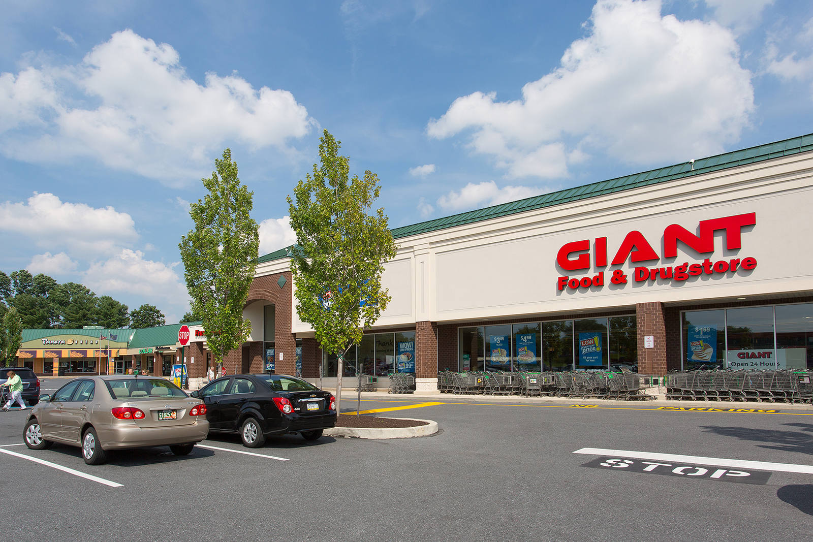 Two trees and cars parked in the parking lot of Giant Food and Drugstore